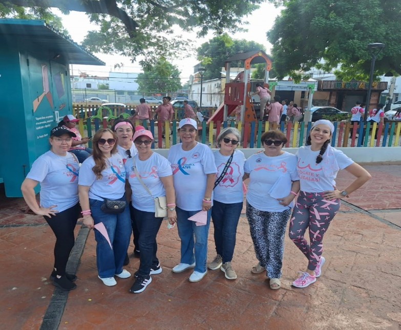 Grupo de mujeres en caminata con lazos rosas
